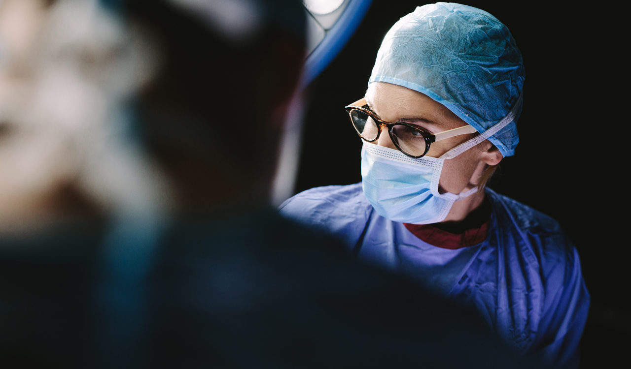 Female surgeon with team performing surgery